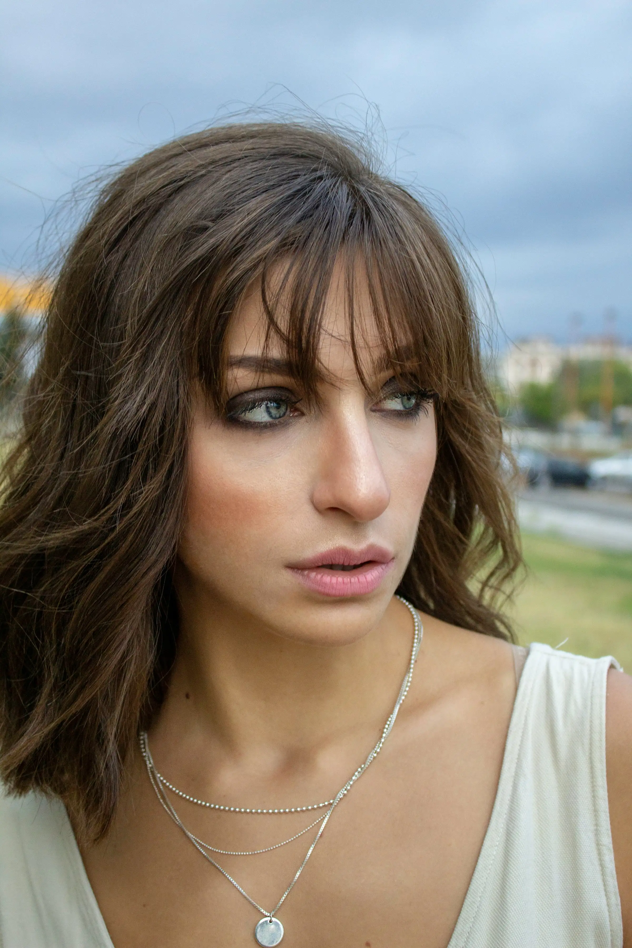 A shaggy brunette cut with a curtain fringe, photographed outdoors