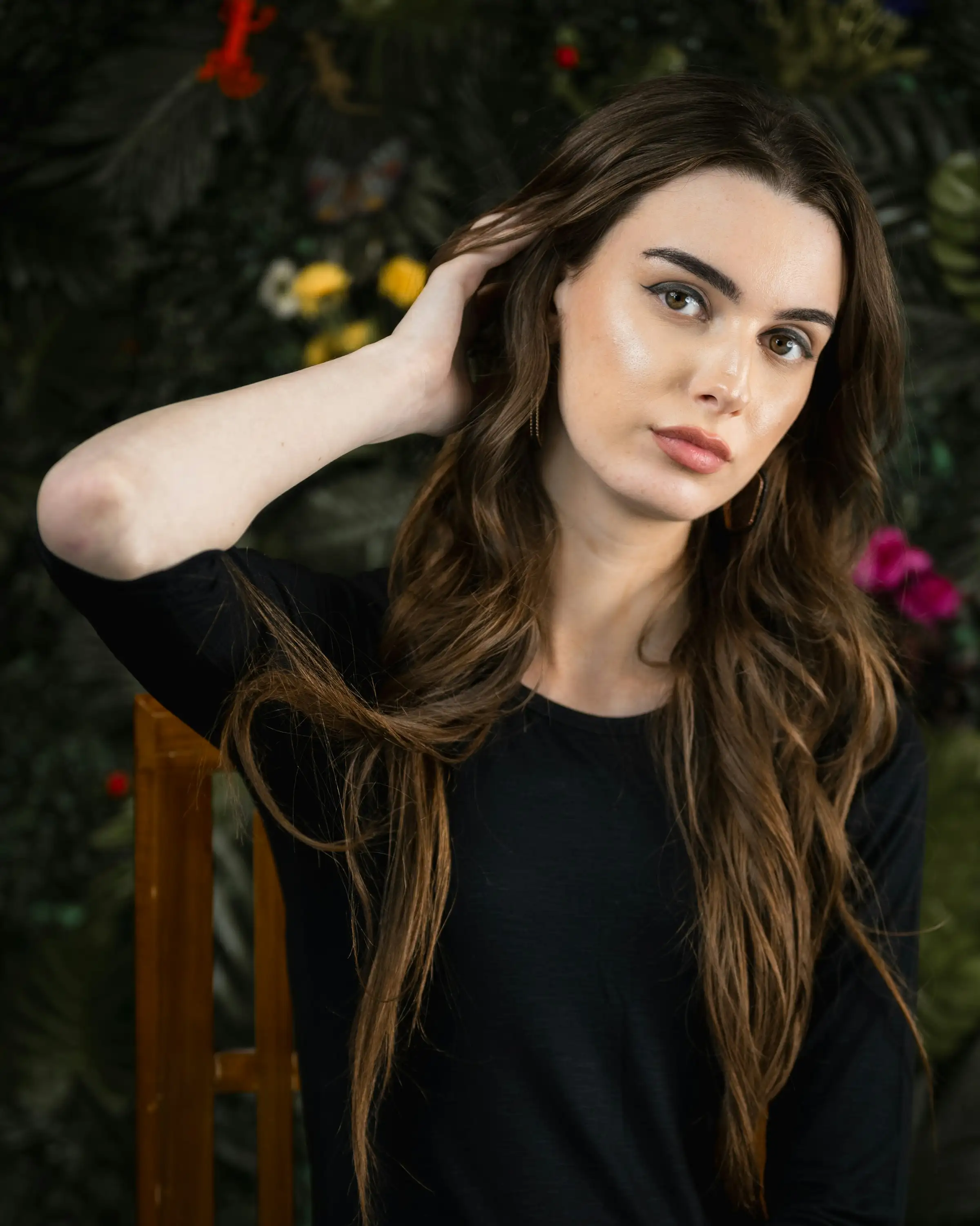 Long, dark waves, one hand lifting the hair at the temple