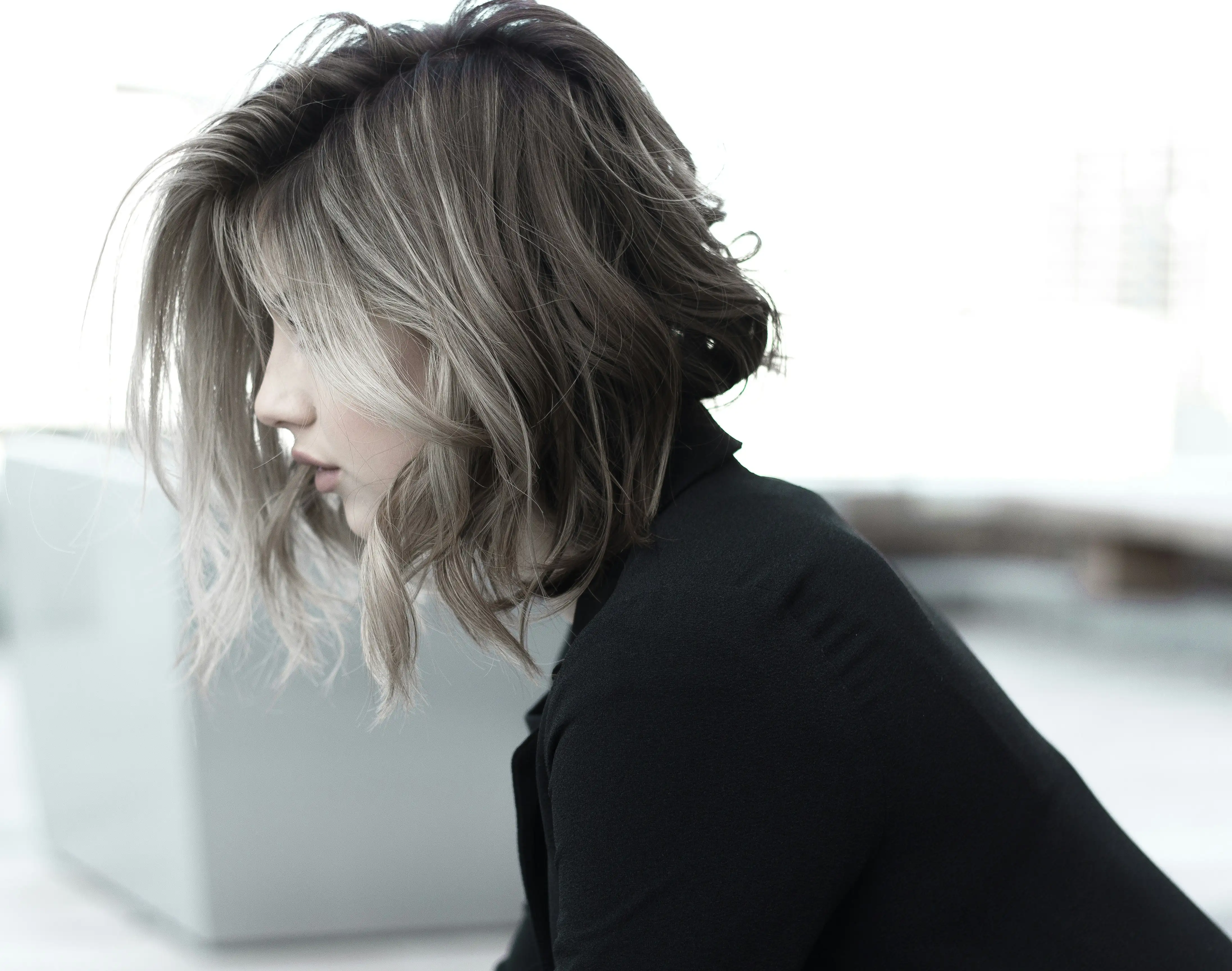 A woman in profile with a short, choppy bob, darker at the roots and lighter at the ends